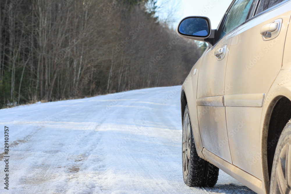Fototapeta premium spring dirt road. beige car sedan.