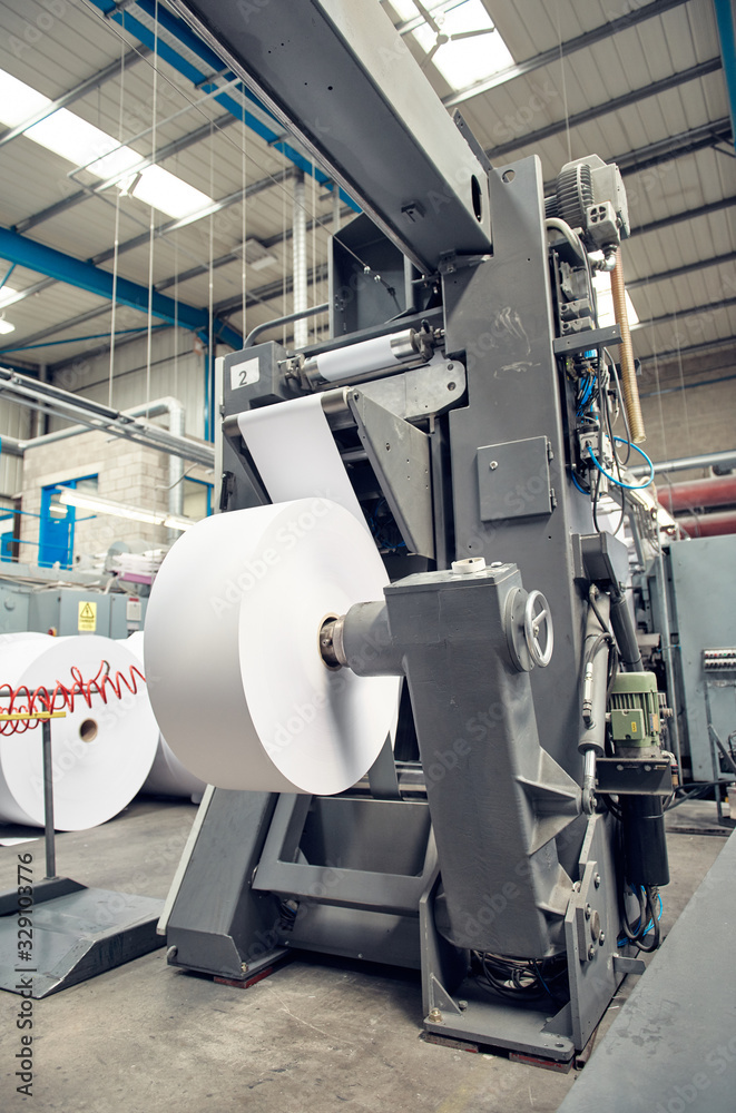 A toilet paper making machine, producing toilet and bathroom paper rolls due to Corona virus panic buying.  Paper and tissue manufacturers factory and engineered machinery.