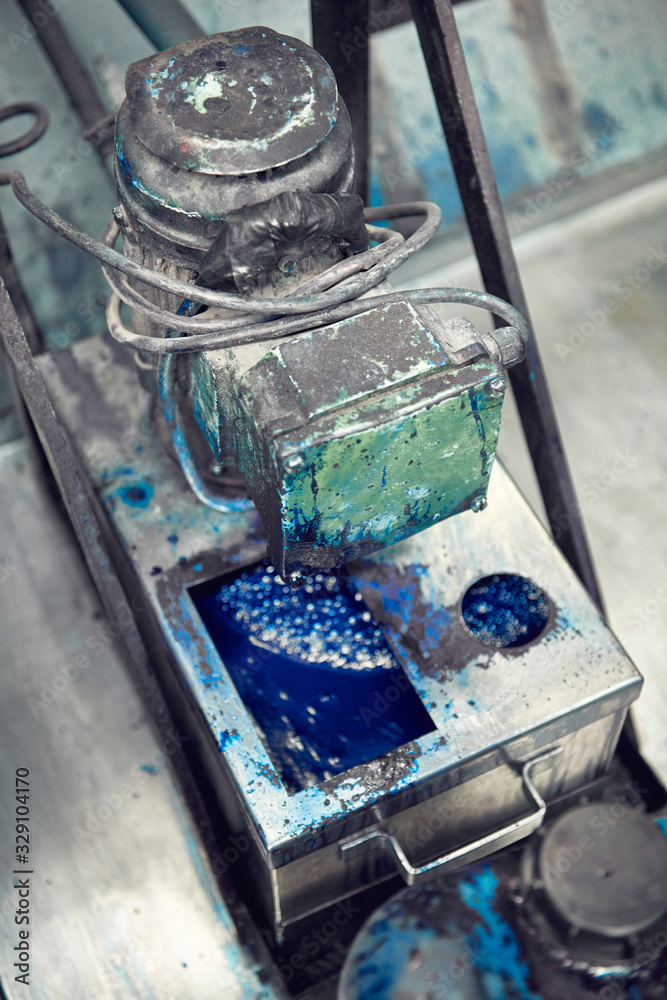 An industrial paint and colour mixing machine mixing paint in an