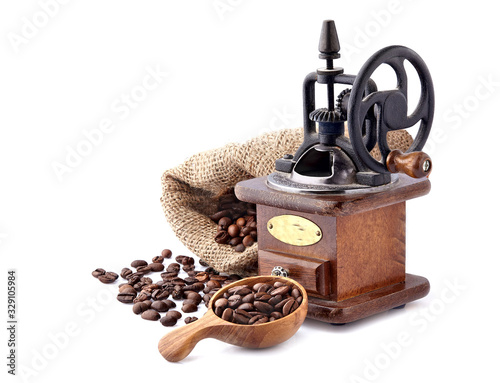 Coffee mill with Coffee beans in a wooden spoon on white background. photo