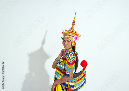 The beautiful woman wearing Thai Tradition southern costume and put headdress on her head,standing on white background,folk dance,black shadow reflection on white background photo