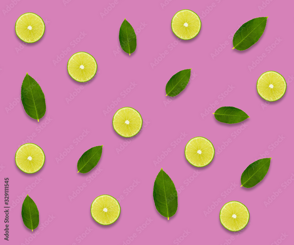 Creative background made of summer tropical fruits with leaves lemon lime on pastel pink background. Creative background made of summer tropical fruits with leaves lemon lime on pastel pink background.