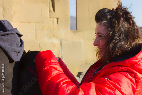 Portrait of a young girl in a red jacket, fluttering hair in the wind photo