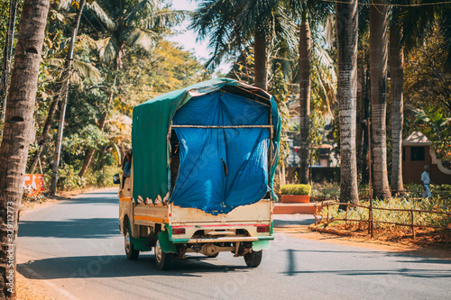 Fototapeta Naklejka Na Ścianę i Meble -  Goa, India. Small Truck Is Moving Along City Street. Back View