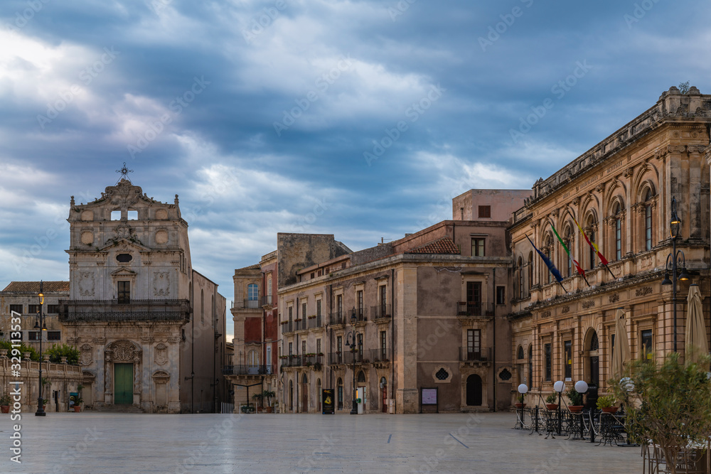 Main square of Ortygia island and view of the catholic church of Saint Lucia alla Badia at sunrise in province of Syracuse in Sicily