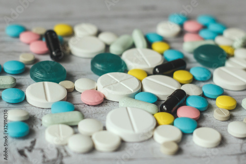 Pills isolated on a wooden light background. Top view with copy space. 