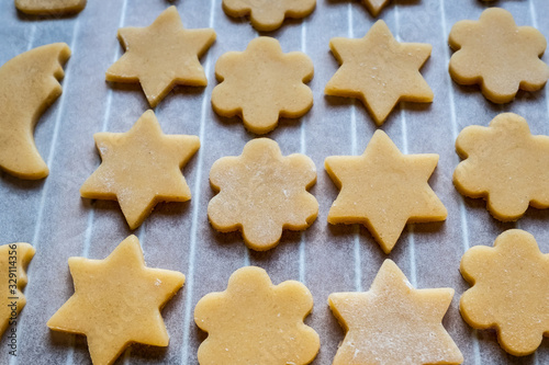 Biscuits sablés étoiles et fleurs sur une plaque de cuisson
