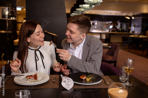 Try it  caucasian couple eat delicious food in luxury restaurant. young married couple treat each other with dessert. love  relationships  restaurant concept. indoors