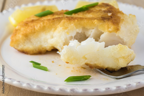 Fried light breaded cod fish.