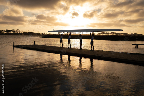 Teammates carrying the rowing boat together
