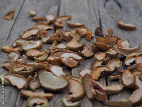 Dried homemade fruit Apple chips or slices on a wooden background. Health benefits of dried fruits  vegetarian food.