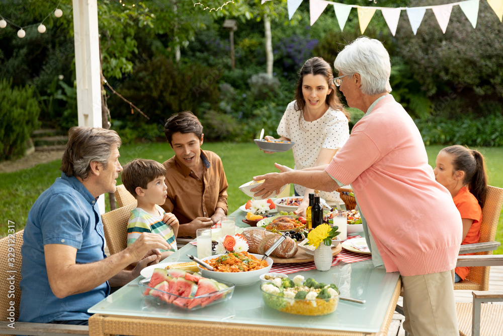 Family eating outside together in summer