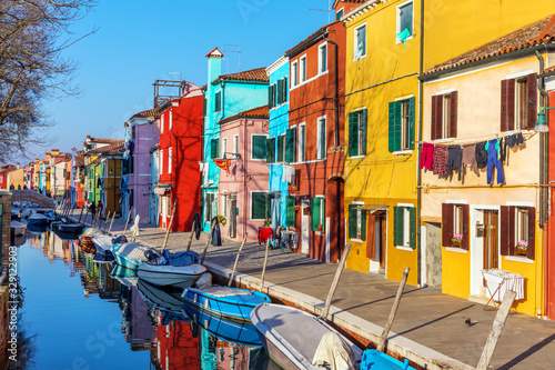 Street with colorful buildings in Burano island  Venice  Italy. Architecture and landmarks of Burano  Venice postcard. Scenic canal and colorful architecture in Burano island near Venice  Italy