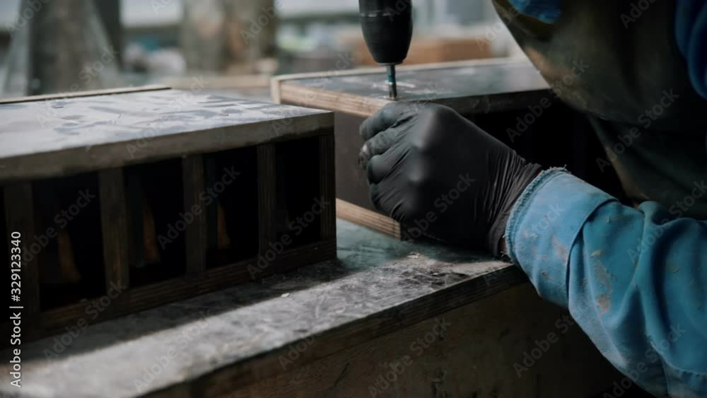 Concrete industry - worker in gloves drills screws in the big concrete item