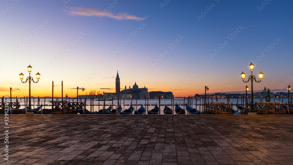 Obraz premium Scenic view of San Giorgio Maggiore, gondolas and lamp at colorful sunrise, Venice, Italy. Sunset in Venice. Gondolas at Saint Mark's Square 