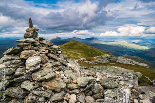 The cairn marking the peak of Ben Vorlich with the scenic Scottish Highlands landscape in the background.  © Maritxu22