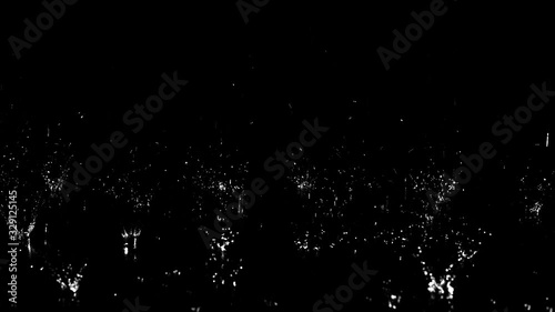 Droplets of rain falling on the surface creating splashes on an isolated background