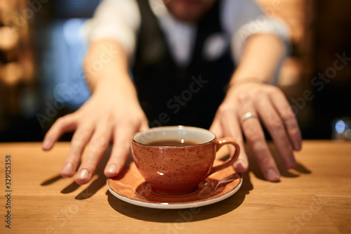 black coffee in orange cup on brown wooden table blurred background.sale discount . close up cropped photo