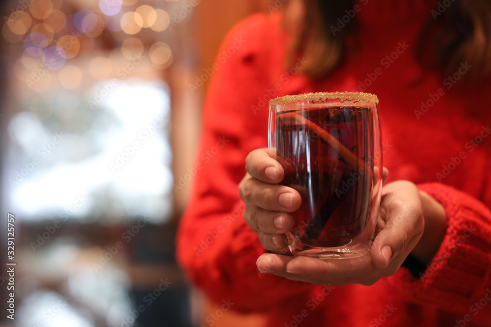 Woman with tasty mulled wine indoors, closeup