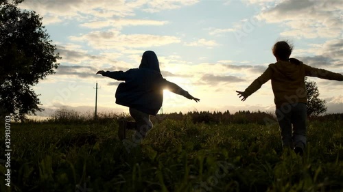 Kids play pilots. A field with a sunset. Slow motion.