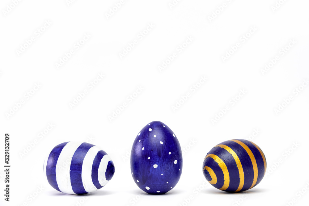 Three easter eggs trendy colored classic blue, white and golden decorated on white table. Happy Easter card with copy space for text. Minimal style. Three easter eggs trendy colored classic blue, white and golden decorated on white table. Happy Easter card with copy space for text. Minimal style.