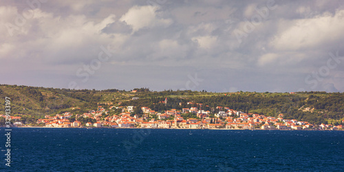 Supetar city in Brac island, Croatia. View from the sea. Picturesque scenic view on Supetar on Brac island, Croatia. Panoramic view on harbor of town Supetar from the side of sea. Brac, Croatia.