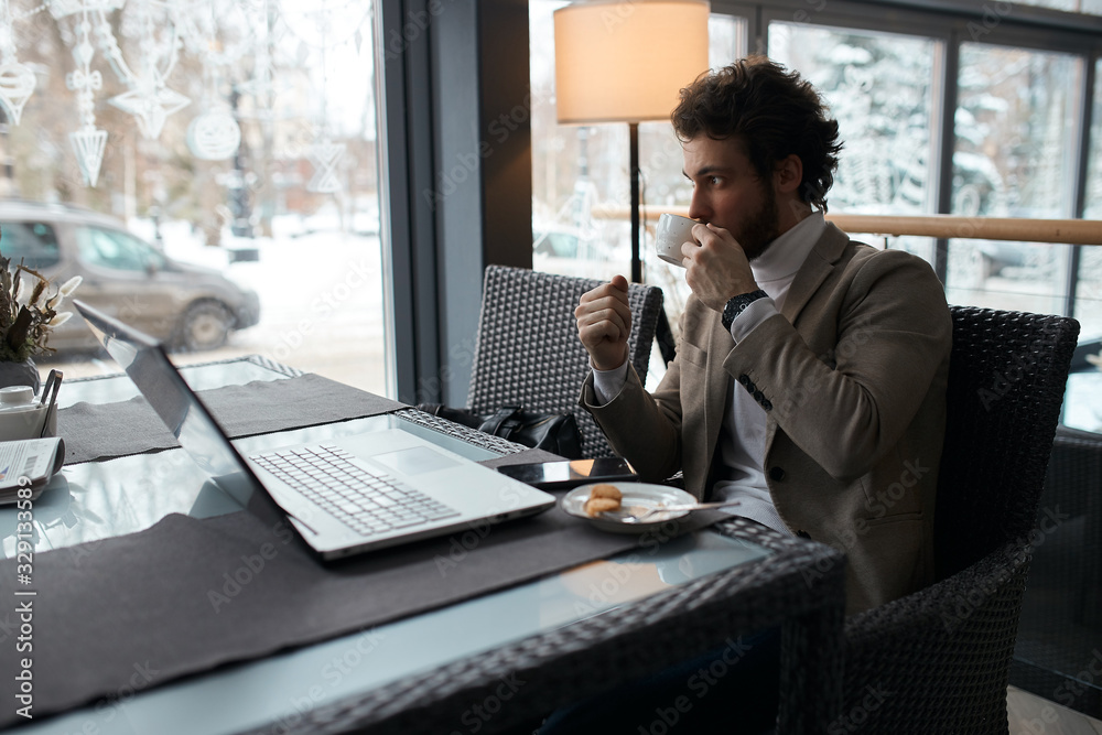 young fashion man drinking tea, having coffee break in the cafe. close up side view photo. young fashion man drinking tea, having coffee break in the cafe. close up side view photo.
