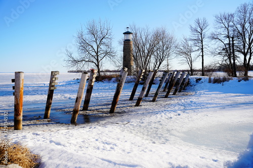 Fototapeta Naklejka Na Ścianę i Meble -  Old vintage historical Asylum Point Lighthouse standing off of the frozen Lake Winnebago out in Oshkosh, Wisconsin during the cold Winter season.