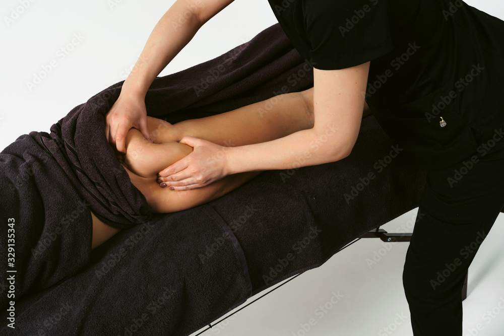 Fat burning massage top view close up. Masseur making anti cellulite massage for young woman in wellness center or beauty salon. Perfect body concept. White background isolated