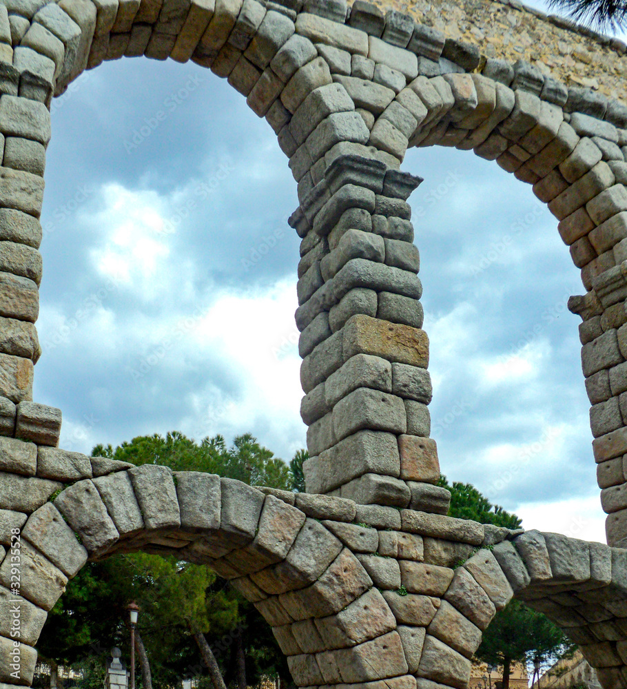 Roman aqueduct in Segovia, Spain. Famous Romanesque architectureis located in the Spanish province of Castilla. Beautiful tourist attraction. Roman aqueduct in Segovia, Spain. Famous Romanesque architectureis located in the Spanish province of Castilla. Beautiful tourist attraction.