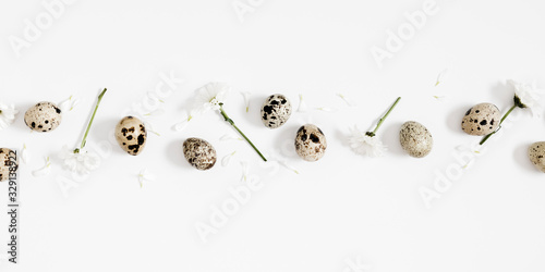 Easter creative composition. Quail eggs and white flowers on white background. Natural easter concept, pattern. Flat lay, top view, copy space 