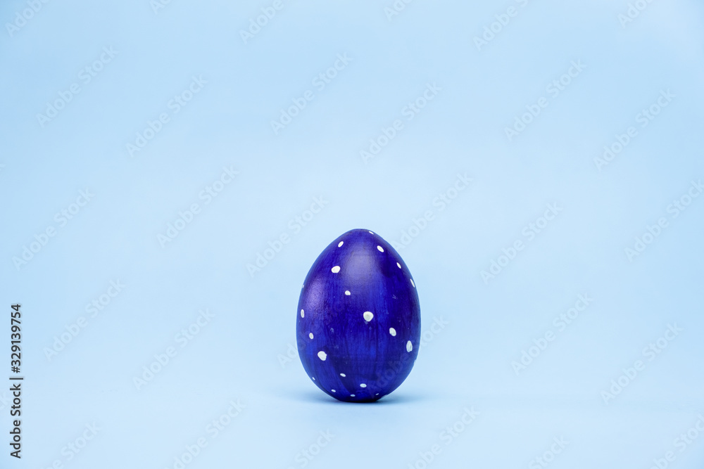 Happy Easter. One easter egg trendy colored classic blue, white and golden on blue background. Copy space. Minimal style