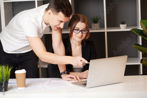 Man and woman working together on a project in the office