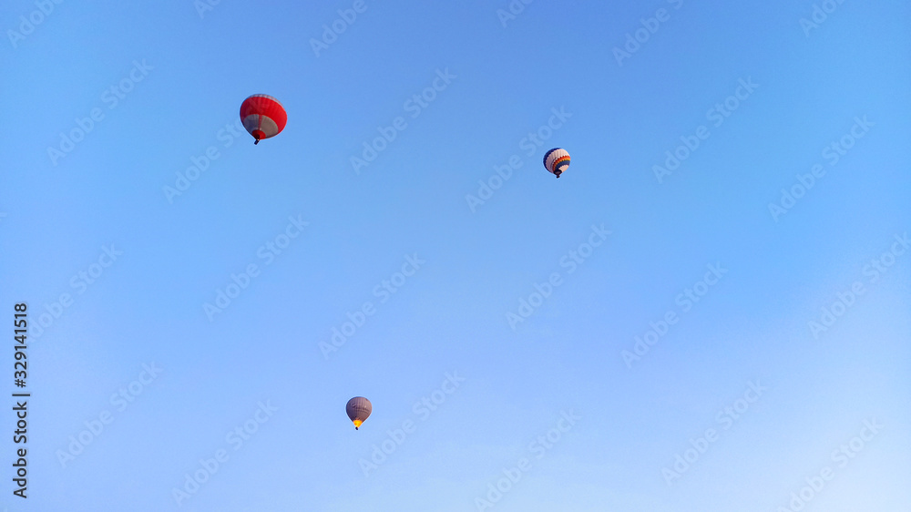 Colorful hot air balloons flying over the valley with fairy chimneys in winter season. Lots of Hot air balloons at the sunrise sky landscape in Cappadocia, Turkey Colorful hot air balloons flying over the valley with fairy chimneys in winter season. Lots of Hot air balloons at the sunrise sky landscape in Cappadocia, Turkey