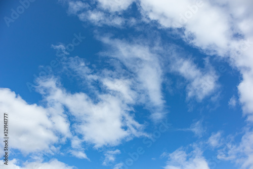 Vibrant blue sky  white fluffy clouds background