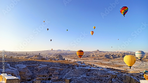 Colorful hot air balloons flying over the valley with fairy chimneys in winter season. Lots of Hot air balloons at the sunrise sky landscape in Cappadocia, Turkey