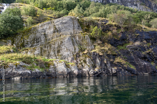 Heavy rocks water reflection in norwegian fjord