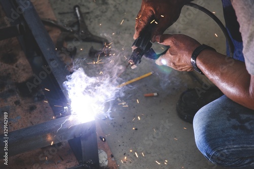 Workers are welding steel without protective gloves.