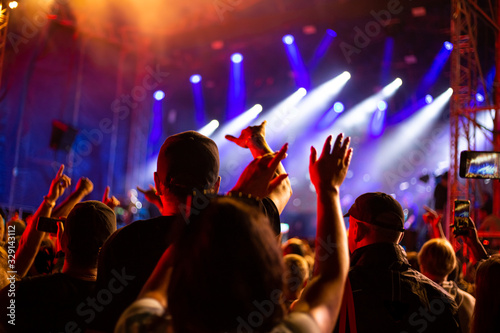 a group of fans raised their hands up at a music concert