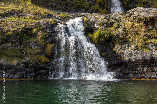 Waterfall falling in norwegian fjord Aurlandsfjord