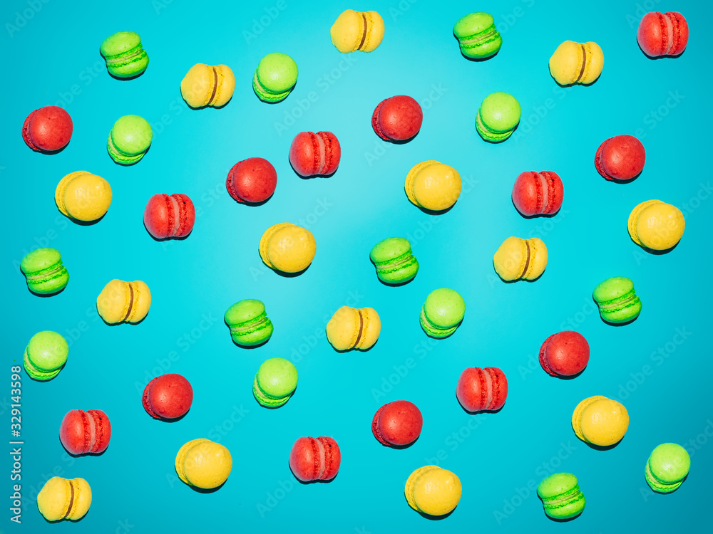 A lot of little colored macaroons on a blue background.