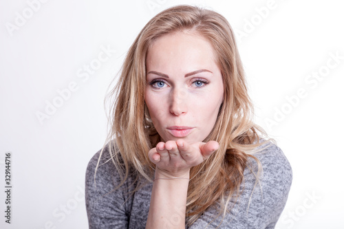 blond woman send kiss over hand greeting