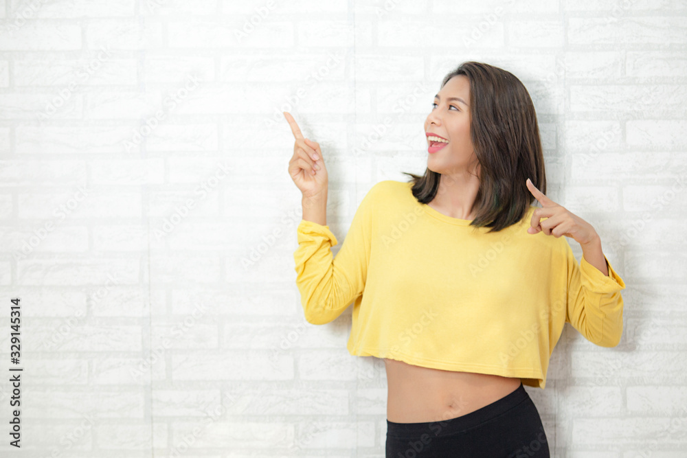 Beautiful girl are happy and smile feeling and point finger you can write message in the space for Advertising Beautiful girl are happy and smile feeling and point finger you can write message in the space for Advertising