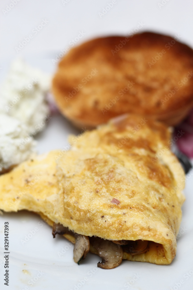 Omelette with fried champignon mushrooms and toasted bread roll Omelette with fried champignon mushrooms and toasted bread roll
