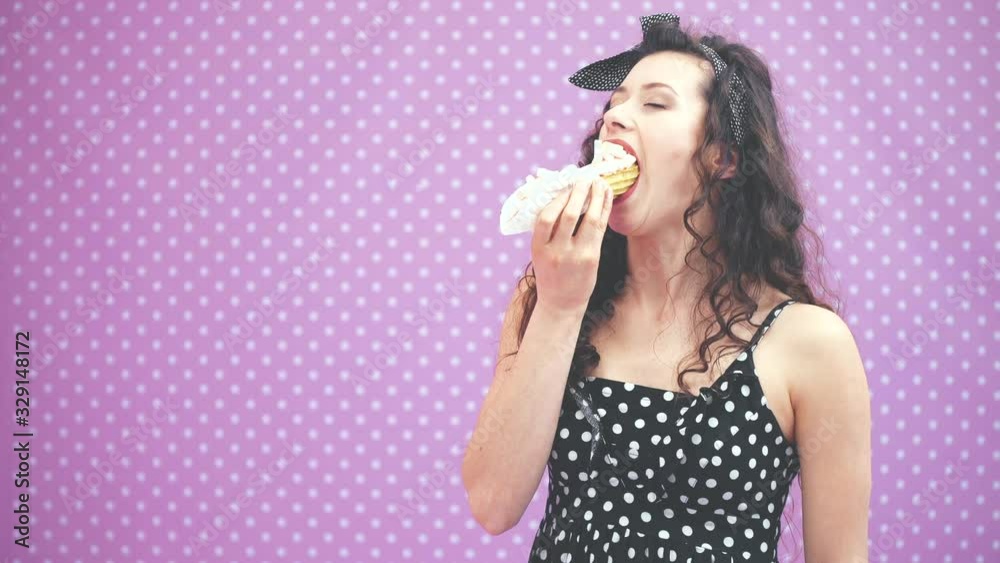 Lovely young curly girl tasting enticingly creamy custard tart with pink topping and marshmallow, giving her thumb up. Pleased face expression. Lovely young curly girl tasting enticingly creamy custard tart with pink topping and marshmallow, giving her thumb up. Pleased face expression.