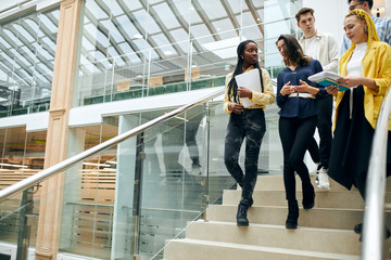 young ambitious talented office workers talking, discussing a new project, copy space, students walking in the building, a group of young people going to attend lecture, lesson, meeting