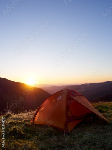 Tent in the mountains at sunset.