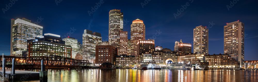 Downtown panoramic city view of Boston Massachusetts looking over the riverfront harbor at night Downtown panoramic city view of Boston Massachusetts looking over the riverfront harbor at night