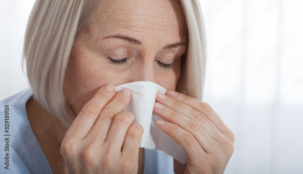 Healthcare, cold, allergy and people concept, sick woman blowing her runny nose in paper tissue on white background Healthcare, cold, allergy and people concept, sick woman blowing her runny nose in paper tissue on white background