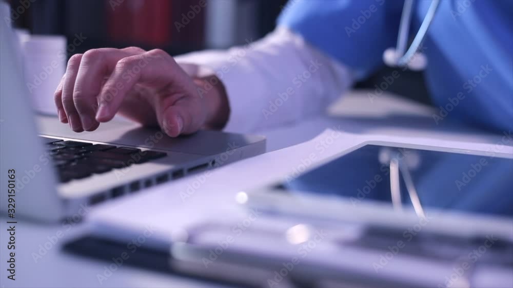 Doctor using digital laptop on modern office, medical technology networking concept.